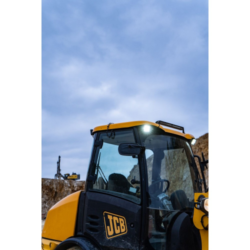 OSRAM LEDriving Cube VX100-WD na bagri JCB 406 – pracovné LED svetlo namontované na kabíne stavebného stroja pri šere