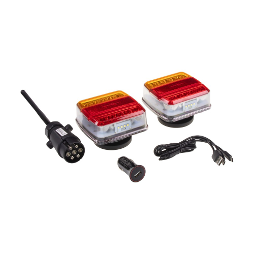 Dve bezdrôtové združené zadné LED lampy na magnetickom podstavci vedľa vysielača 7-pin, USB kábla a nabíjačky do auta